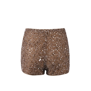 Détail du tissu à paillettes bronze sur un mini short de fête scintillant pour femme