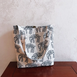 Detail of canvas handbag featuring artistic sheep pattern and bronze magnetic snap