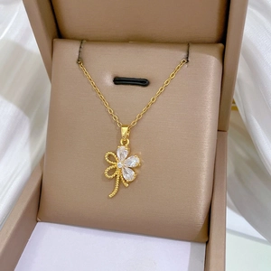 Detail einer Gold-Titan-Halskette mit hohlgearbeitetem Blumenanhänger und klaren Zirkonen