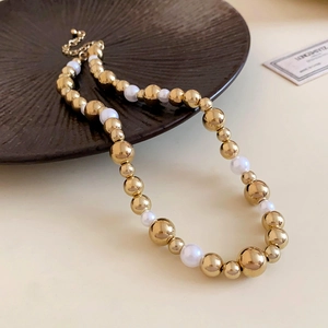 Detailed macro view of gold metal beads and white pearls on an elegant choker necklace