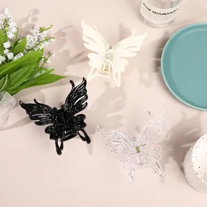 Detailed view of large butterfly hair claws in black, cream, and transparent colors