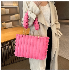 Detailed shot of a pink plush tote bag featuring a metallic chain and fluffy pom-pom handle