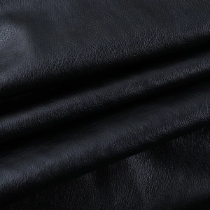 Macro view of high-quality black faux leather texture with subtle grain and soft sheen