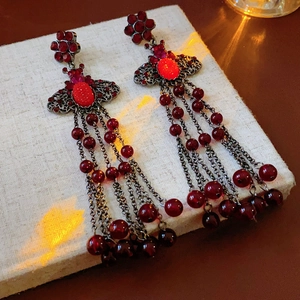 Detail of luxury French style red bee earrings with long tassel and drop hollow design
