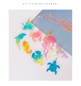 Detailed flat lay of ocean themed resin earring pendants with colorful glitter finishes