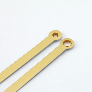 Brushed gold quartz clock hands with precise circular hole design in minimalist style