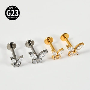 Detail view of gold and silver G23 titanium butterfly labrets with sparkling cubic zirconia