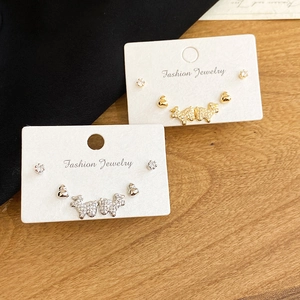 Détail du coffret de bijoux fantaisie comprenant des puces d'oreilles chien et géométriques