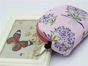Detail of pink floral fabric coin purse with sturdy metal ring and secure zipper closure