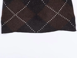 Macro view of brown and black argyle knit fabric texture and high-quality hem detail