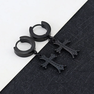 Detail of gothic cross charms on black titanium steel hoop earrings with textured finish