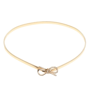 Close-up of golden elastic spring waist belt featuring a decorative metal bow clasp
