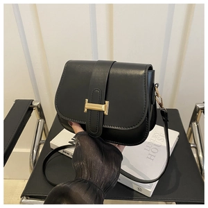 Detailed close-up of a black leather saddle bag with a golden H-shaped metal buckle