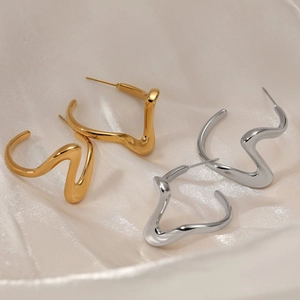 Abstract wavy spiral earrings in polished gold and silver finish on silk fabric