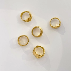 Macro shot of five 18K gold plated stainless steel rings with unique fluid lava textures