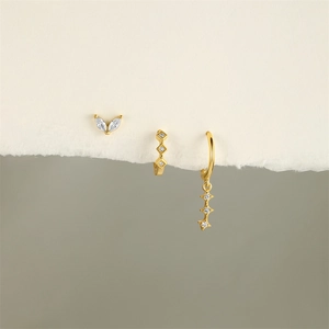 Detailed shot of gold plated earrings featuring marquise zircon and star charms