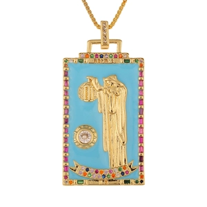 Close-up of golden Hermit tarot pendant with blue enamel and colorful gemstones