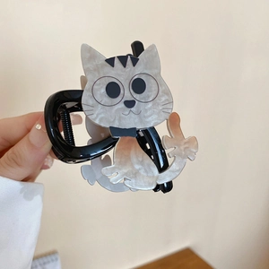 Détail de la pince à cheveux en forme de chat gris nacré avec motifs marbrés noirs