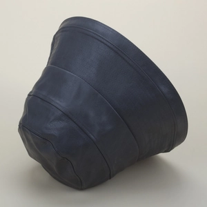 Détail d'un chapeau bob en cuir noir avec surpiqûres parallèles et texture haut de gamme