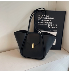 Détail de sac cabas en cuir noir avec coupe 3D et boucle métallique dorée élégante