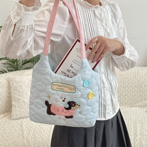 Detalle del bolso acolchado azul claro con bordado de perrito y correas rosas