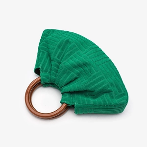 Detail of green pleated velvet handbag with a round brown wooden handle on white background