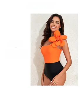 Detail of one-shoulder bodysuit with orange 3D floral decoration and black contrast design