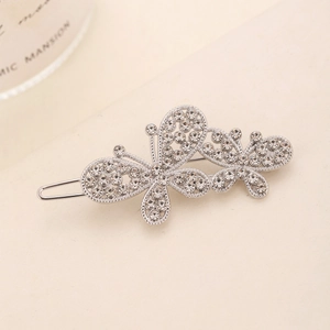 Macro view of silver butterfly hair clip featuring hollow design and sparkling rhinestones