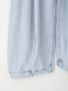 Detailweergave van lichtblauwe denimstof met versterkte naden en geweven textuur