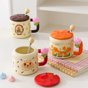 Ceramic tulip mugs with lids and flower spoons in brown, red, and orange tones