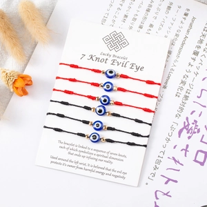 Dettaglio di 6 braccialetti cordino malocchio in rosso e nero su scheda display