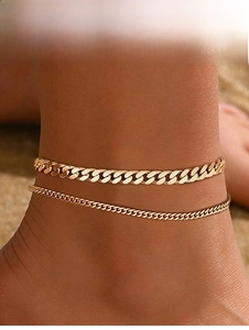 Double-layered gold Cuban link anklets for women shown on a beach during a vacation