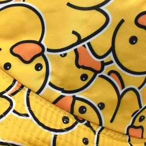 Macro detail of high-density yellow duck print fabric and precise double-line stitching