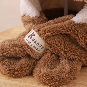 Détail du tissu en peluche marron du chapeau pour enfants avec étiquette et bordure