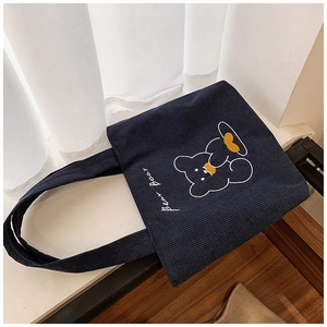 Detail of navy blue corduroy tote bag with white bear baby embroidery and soft texture