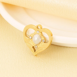 Macro detail of a golden heart pendant featuring a centered pearl and zircon accents