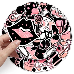 Close-up of pink and black party graffiti stickers featuring lips and lollipop designs
