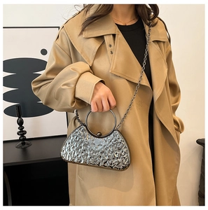 Silver hammered texture evening bag with circular handle and chain strap on model