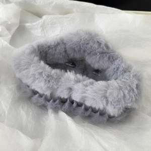 Macro shot of fluffy grey plush hair claw clip with soft faux fur texture for winter style