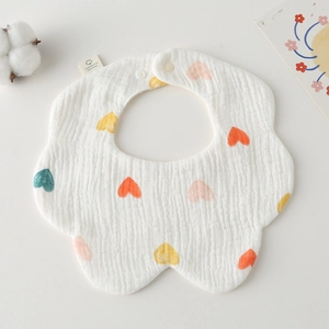 Detail of petal-shaped cotton gauze baby bib with colorful heart print and snap button