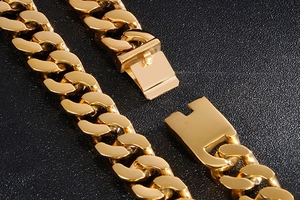 Macro detail of gold-plated stainless steel Cuban link chain with secure box clasp