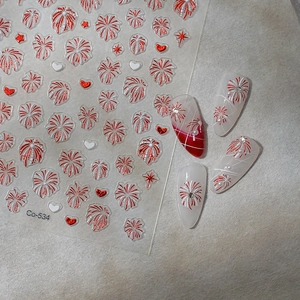 Detail of red firework and heart nail stickers applied on nails with pearl accents