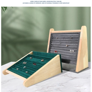 Detail view of wooden jewelry display trays with velvet slots for rings and earrings