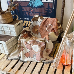Retro bohemian floral knit camping blanket with tassels in orange and brown tones