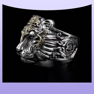 Vintage tiger head ring with golden accents and engraved patterns on black background