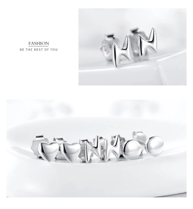 Macro detail of S925 sterling silver mini stud earrings in heart and lightning shapes