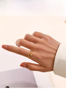 Close-up of minimalist wave-shaped 18K gold-plated stainless steel ring on finger