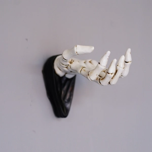 Detailed view of 3D white skeleton hand wall hook with realistic resin bone textures