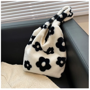 Close-up of the soft plush texture and black and white flower pattern on the handbag