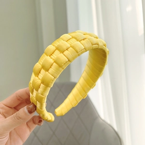 Detail of hand-woven bright yellow satin headband with textured silk finish
